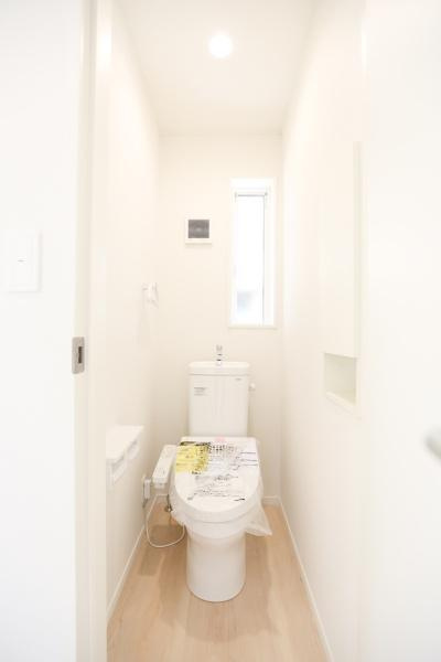 泉町第1-1号棟のトイレ|明るい空間が印象的なトイレです。スリムなレイアウトで動線も確保されています。窓から自然光が入るため換気もしやすい仕様です。シンプルで清潔感のあるデザインが特徴です。