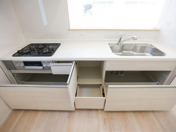 泉町第1-1号棟のキッチン|収納スペースがしっかりと確保されたキッチンです。広々としたカウンターが使いやすそうです。天井照明が空間を明るく照らし、清潔感のある雰囲気です。