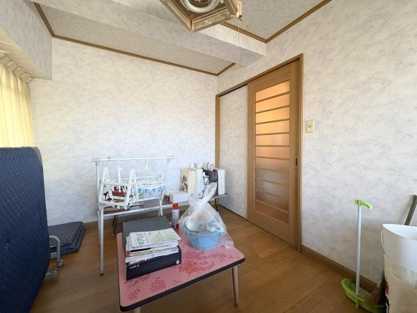 サンコーポ新川の洋室|洋室はナチュラルなフローリングと優しい色合いの壁紙が特徴です。スライドドアで空間を有効に活用できます。天井のラインや採光にも工夫が見られます。窓からの柔らかな日差しが明るさを演出しています。