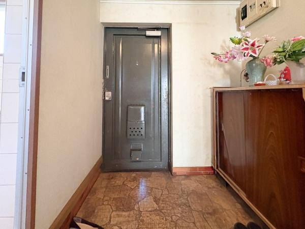 サンコーポ新川の玄関|玄関スペースは落ち着いた色合いでまとめられています。シューズボックス上には花や小物が飾られており雰囲気づくりに役立ちます。ドアはしっかりとした造りですので安心感があります。