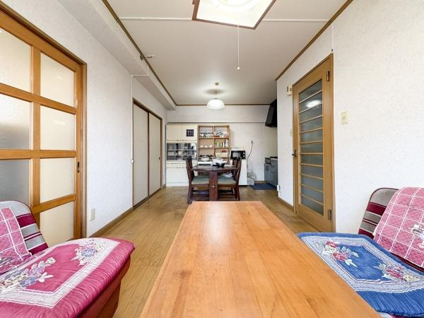 サンコーポ新川の居間・リビング|明るい光が差し込むリビングです。ゆとりある広さで家具の配置がしやすい空間となっています。木目調の床が温かみを感じさせます。清潔感のある内装が印象的です。スライドドアが使いやすい設計となっています。