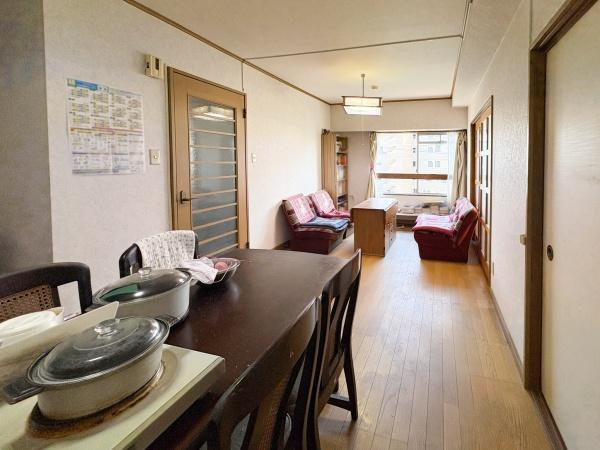 サンコーポ新川の居間・リビング|リビングは奥行きがあり開放感を感じられます。窓からの明るい光が室内を照らし快適な空間となっています。家具の配置もしやすい間取りです。ウッド調の床が温かみを与えています。