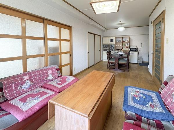 サンコーポ新川の居間・リビング|リビングはナチュラルな色合いの床で落ち着いた空間です。明るい雰囲気が広がります。ドアや壁面もシンプルですっきりとした印象の使い勝手が良いリビングです。