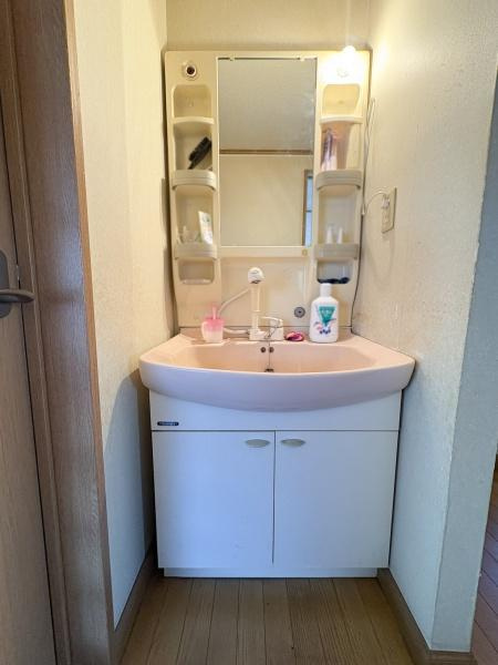 サンコーポ新川の独立洗面台|コンパクトなサイズ感の洗面台でスペースを有効活用できます。収納スペースが上下にあり日用品の整理にも便利です。明るい照明付きで日常の使い勝手も良好です。清潔感のあるシンプルなデザインが特徴です。