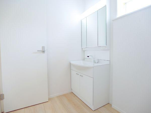 寒田北町第1-2号棟の独立洗面台|三面鏡タイプの洗面化粧台は、角度を変えて身だしなみをチェックできる実用性の高い仕様。収納スペースも広く、スキンケア用品や小物類もすっきり整理できます。毎日の準備が快適になる設備です♪