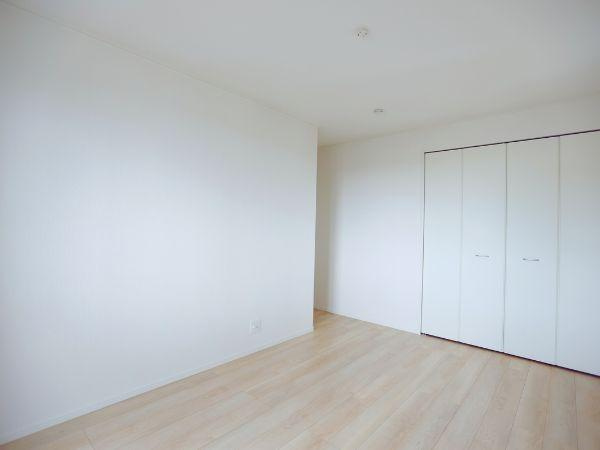 寒田北町第1-2号棟の洋室|シンプルで使いやすい洋室。明るい色合いのフローリングが印象的です。収納スペースがしっかりと確保されており、落ち着きのある雰囲気の内装です。家具の配置もしやすい間取りです。