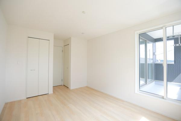 寒田北町第1-2号棟の洋室|明るい光が差し込む洋室です。クローゼットが備え付けられており収納スペースも確保されています。白を基調とした内装がすっきりとした印象を与えます。バルコニーへのアクセスも便利な洋室です。