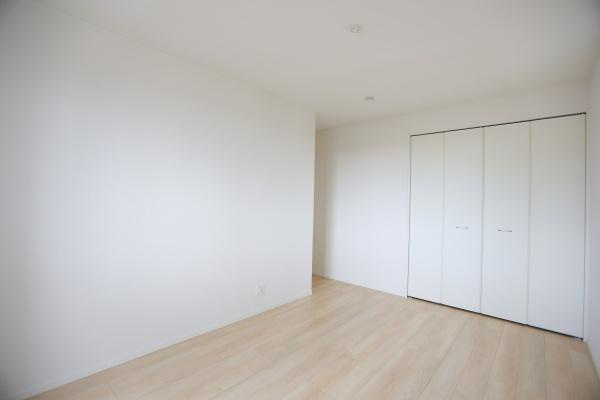 寒田北町第1-2号棟の洋室|白を基調とした洋室で清潔感のある内装が印象的です。明るい床材が室内を広く見せています。収納スペース付きで機能性にも配慮されています。落ち着いた雰囲気が魅力の空間です。