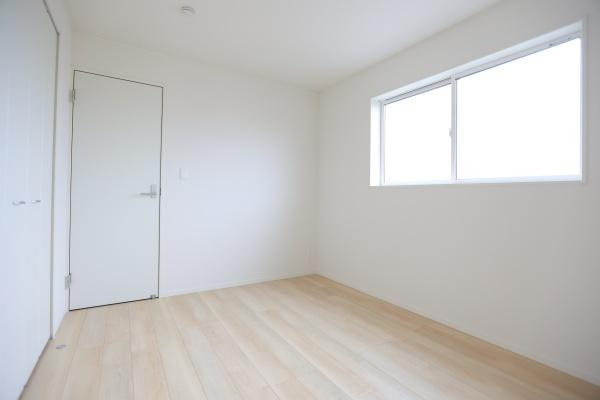 寒田北町第1-2号棟の洋室|明るい色合いのフローリングが印象的な洋室です。大きな窓から光がしっかり入り開放感があります。白い壁と天井が空間をすっきりと見せています。シンプルなデザインで使いやすい洋室です。