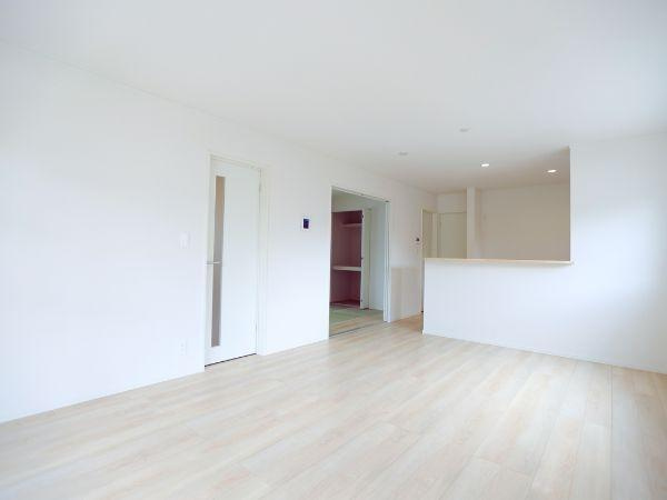 寒田北町第1-2号棟の居間・リビング|落ち着いた色合いのフローリングが特徴的です。天井のダウンライトが室内を明るく演出します。