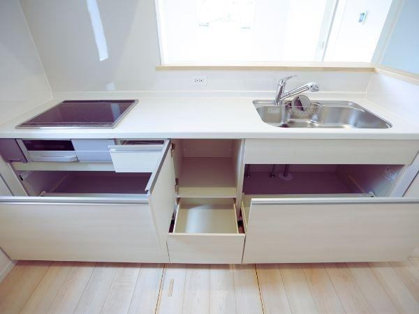 寒田北町第1-2号棟のキッチン|収納スペースがしっかりと確保されたキッチンです。広々としたカウンターが使いやすそうです。天井照明が空間を明るく照らし、清潔感のある雰囲気です。