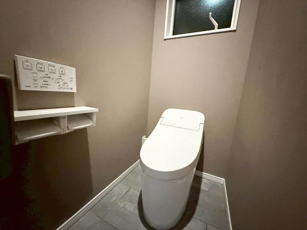 駄原中古のトイレ|落ち着きのある色合いのトイレ空間です。壁付けのリモコンやペーパーホルダーも設置されています。窓があるため換気もしやすい設計です。