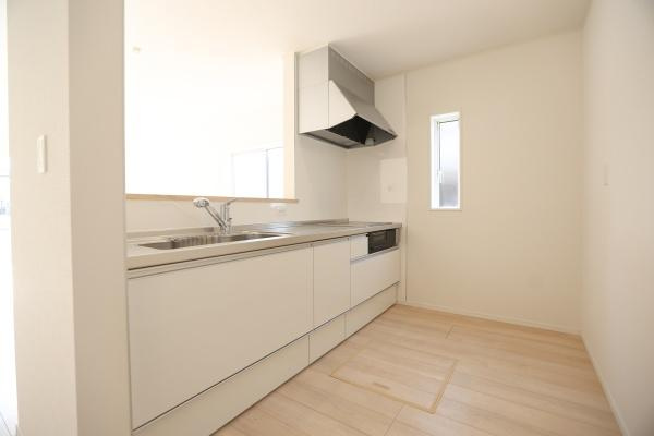 猪野第4-1号棟のキッチン|明るい色合いのキッチンが清潔感ある空間を演出しています。作業スペースが広く使いやすさにも配慮されています。収納もしっかりと確保されており整理整頓がしやすいです。換気扇やシンクも洗練されたデザインです。