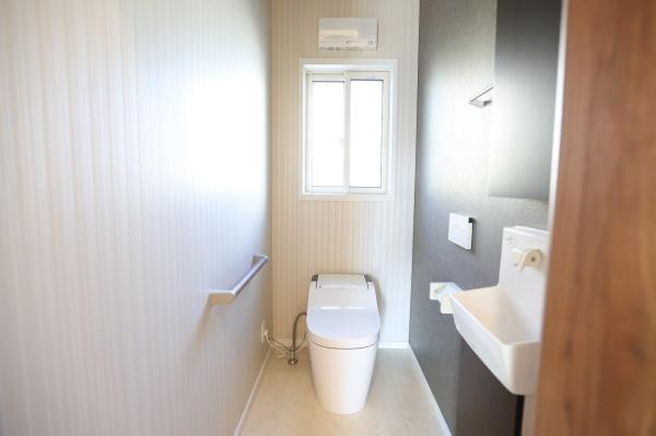 大字角子原　中古のトイレ|清潔感のある空間が広がっています。自然光が差し込む窓付きで明るい雰囲気です。手すりや収納スペースも備え付けられており使い勝手に配慮されています。