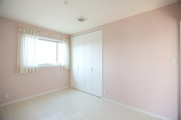 大字角子原　中古の洋室|淡いピンクの壁が印象的な洋室です。大きな窓から光が差し込み室内が明るく感じられます。収納スペースも確保されておりすっきりとした空間です。シンプルな内装で家具の配置もしやすくさまざまな使い方が可能です。