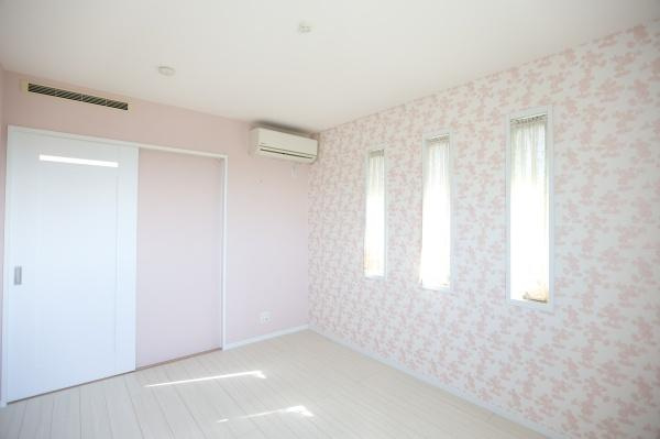 大字角子原　中古の洋室|ピンクを基調としたアクセントクロスが印象的な洋室です。三連の縦長窓から自然光が差し込み明るい空間となっています。エアコンが設置されており快適な環境を保てます。