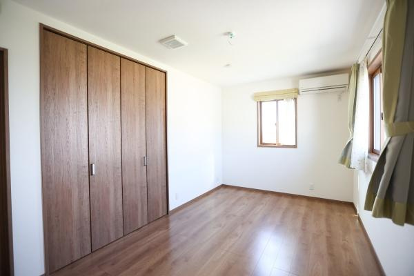 大字角子原　中古の洋室|木目調の床と扉が空間に温かみをプラスしています。収納スペースも豊富で整理しやすく落ち着いた雰囲気が特徴です。エアコン付きで快適に過ごせます。