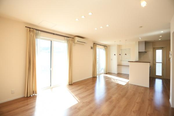 大字角子原　中古の居間・リビング|大きな窓から光が差し込むリビングです。天井のダウンライトが室内を明るく演出します。キッチンとのつながりも良好です。