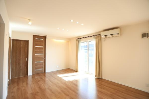 大字角子原　中古の居間・リビング|大きな窓からの採光でリビングが明るく感じられます。木目調のフローリングが空間に温かみを与えています。エアコンが設置されているので一年を通して快適に過ごせます。