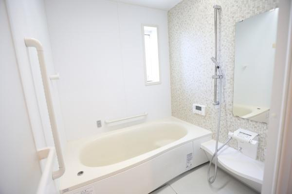 大字角子原　中古の浴室|シンプルで清潔感のあるバスルームです。白を基調とした内装が明るさを演出しています。壁面のアクセントが落ち着いた雰囲気を与えています。浴槽も広めの設計です。