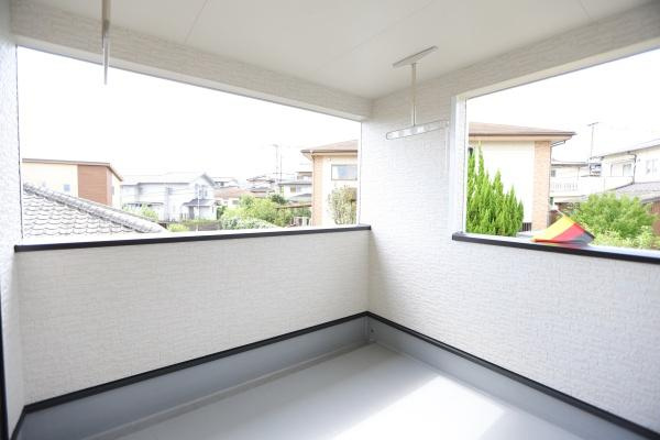 寒田北町第1-1号棟のバルコニー|開放感のあるバルコニーが魅力です。周囲の住宅街を眺められる空間でゆったりとした時間を過ごせます。屋根付きなので天候の影響も軽減されます。シンプルなデザインでお手入れもしやすいバルコニーです。