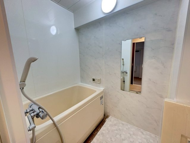 シティコーポ堀田の浴室|壁・天井パネル貼りと床シート貼りで清潔感アップ。浴槽・照明・鏡・排水ふた・扉・換気扇を交換し、快適で使いやすいバスルームを実現しました。