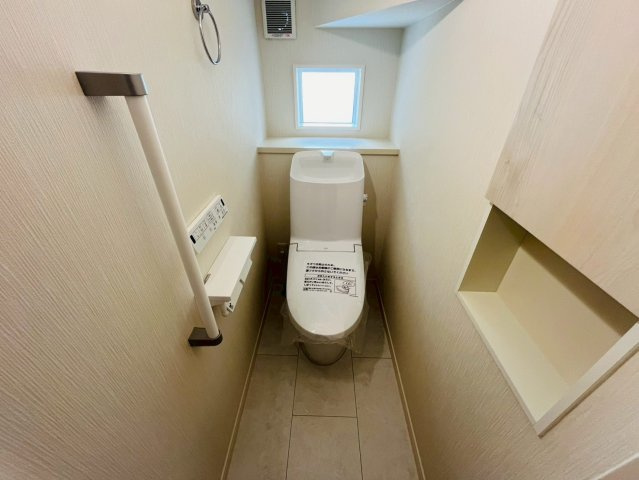 久喜市吉羽　第6期　全5邸のトイレ|〇トイレ〇
デットスペースをうまく活用した1Fトイレ。うれしい手すり＆タオル掛け付き！収納棚付きなので、トイレットペーパーやお掃除道具などを収納しておくことができます（＾＾）
2025年10月撮影