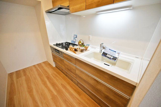 吹田ロイヤルマンションのキッチン|木目調はナチュラルで暖かみのある雰囲気のキッチンにすることができ、茶色の効果で落ち着きのある空間にすることもできます。 フローリングの木目とも相性が良いです。