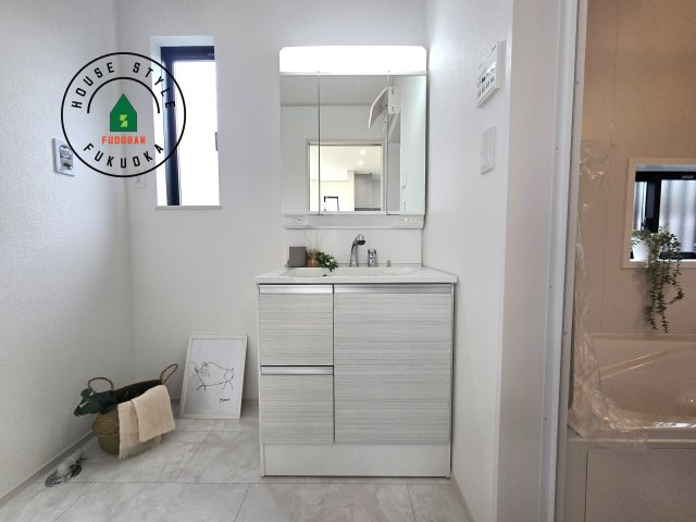 福岡市東区美和台5丁目第1-2棟(A号棟)の内観：施工例|毎日使うものだから清潔な空間を保ちたい水回り。洗面にはそんな願いを解消させてくれる収納アイデアが満載です。三面鏡の裏側にはキャビネットが現れ小物から背の高い物まで収納できます。