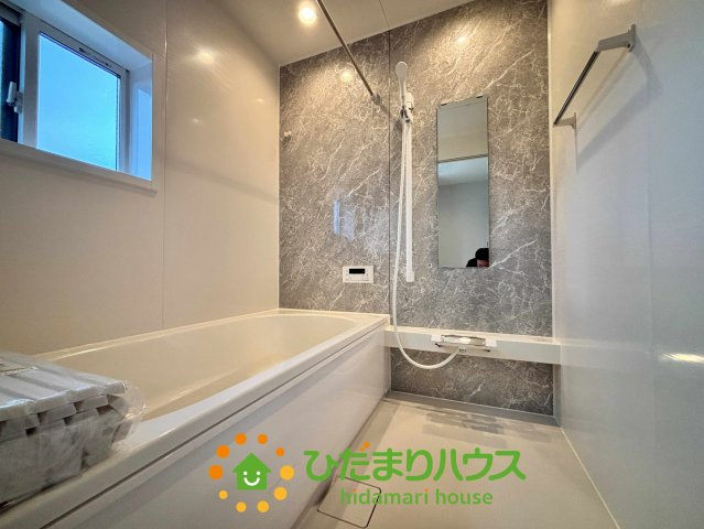 ワイウッドコート加須市多門寺第11期　新築一戸建て　01の浴室|一日の疲れを癒やす、落ち着いた雰囲気のユニットバス！グレーの壁面パネルが上品さを演出し、ゆったりと足を伸ばせる浴槽でリラックスタイムを満喫できます。