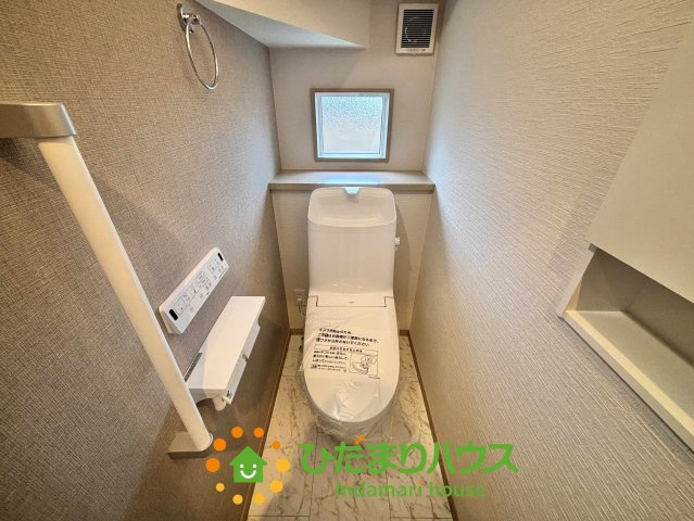 ワイウッドコート加須市多門寺第11期　新築一戸建て　01のトイレ|清潔感あふれるシンプルなデザインのトイレ空間。上部には小窓を設け、換気と自然光を確保しています。トイレットペーパーのストックや芳香剤を置けるカウンターもあり、機能性と快適性を両立した設計です。