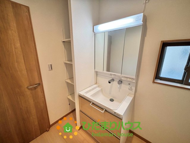 ワイウッドコート加須市多門寺第11期　新築一戸建て　02の独立洗面台|三面鏡の裏側までたっぷり収納できる洗面化粧台です！散らかりがちな小物もスッキリ片付き、忙しい朝の準備もスムーズに進みます。木目調のデザインが空間に溶け込み、毎日の身支度を穏やかな気持ちで行えますね♪