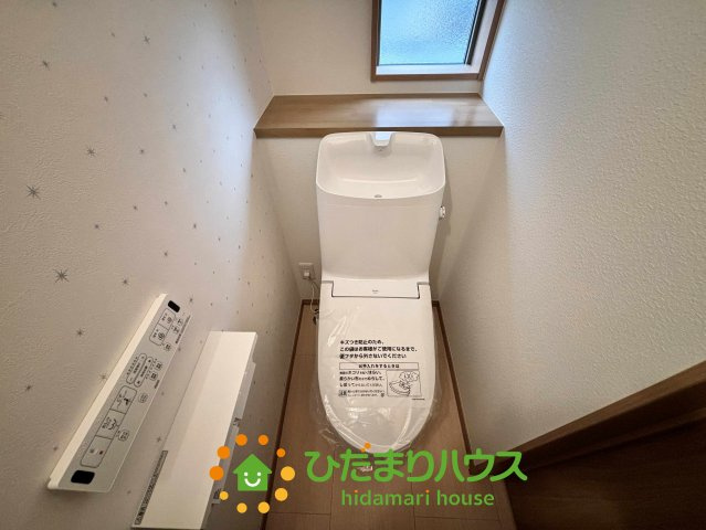ワイウッドコート加須市多門寺第11期　新築一戸建て　02のトイレ|清潔感あふれる温水洗浄便座付きのトイレです！壁紙の星柄がさりげないアクセントになり、明るく楽しい空間に。お掃除がしやすい形状の便器を採用しており、家事の負担を減らしながら毎日気持ちよく使用できます♪