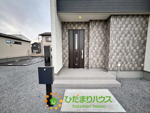 ワイウッドコート加須市多門寺第11期　新築一戸建て　02の玄関|雨の日でも濡れにくい、ゆったりとした屋根付きの玄関ポーチです！夜間はダウンライトが優しく足元を照らし、帰宅する家族を温かく迎えてくれます。洗練されたポストやインターホンも、外観と調和していますね♪