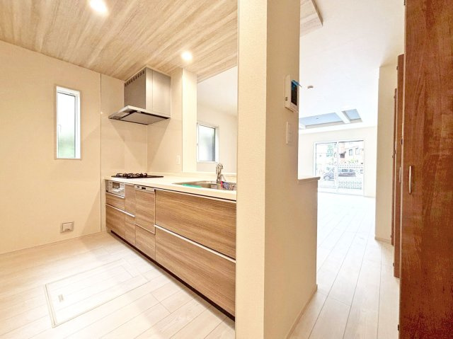 ブルーミングガーデン末成町新築一戸建て│3LDK+並列駐車2台可のキッチン|1階キッチンユニット越しに撮影した内観写真です。対面式キッチンを採用しているため視界は広く、ご家族間やご来訪者とのコミュニケーションも一体的に取り易くなっております。