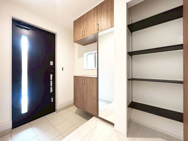 ブルーミングガーデン末成町新築一戸建て│3LDK+並列駐車2台可の玄関|1階玄関を廊下側から撮影した内観写真です。
シンプルな玄関扉にシューズボックスを配置したオーソドックスな玄関です。