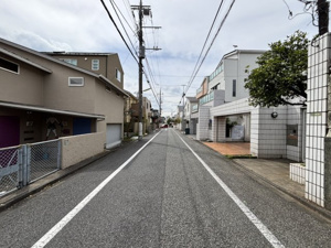 【前面道路含む現地写真】 | 白を基調としたタイル貼りの外壁が、青空に美しく映える邸宅。前面道路はゆとりある幅員が確保され、見通しも良くお車の出し入れもスムーズです。落ち着いた街並みの中で、家族の新しい生活がここから始まります♪