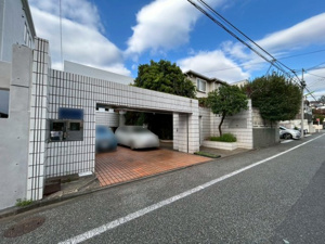 【前面道路含む現地写真】 | 平坦な道路に面した開放的な立地。お車の駐車はもちろん、自転車やベビーカーの出し入れもストレスフリーです。角地の開放感と陽当たりの良さを享受できる住環境で、お子様との散歩も楽しくなること請け合い！