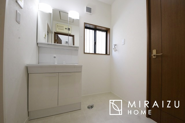 【洗面所】 | 洗濯機置き場と脱衣スペースもしっかりと確保されている洗面室、洗面コーナーは、窓から陽も差し明るく開放的な造りです。家事導線も良いので洗濯物やお湯はりもストレスフリーに毎日家事を楽しめそうです。
