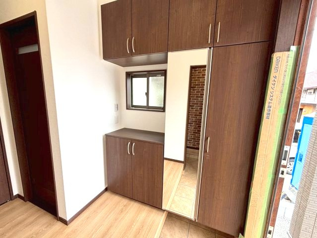 城山団地1丁目　新築戸建ての玄関|玄関には姿見付きの下駄箱を設置しています。家族全員の靴がたっぷり収納できます。