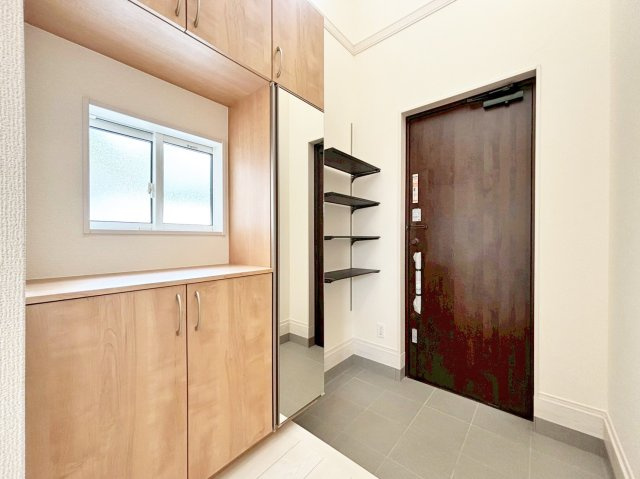 ブルーミングガーデン中山五月台1丁目新築一戸建て全2区画│3・4LDK+並列駐車2台可の玄関|1階玄関をホール側から撮影した内観写真です。 シンプルな玄関扉にシューズボックス、小窓を配置、上部に吹抜が設けられた明るく開放的な玄関です。