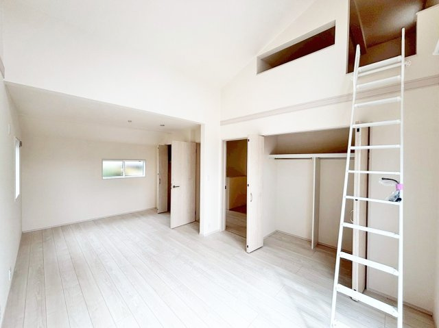 ブルーミングガーデン中山五月台1丁目新築一戸建て全2区画│3・4LDK+並列駐車2台可の居間・リビング|2階主寝室想定に入ってすぐの内観写真です。勾配天井で開放感溢れる一室となっております。上部には室内物干し竿が設置されています。