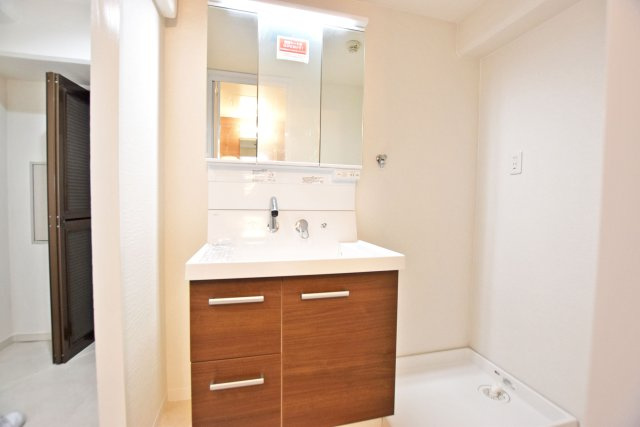 緑地東ロイヤルマンションの洗面所|洗面台の下部だけでなく鏡の裏側にも収納スペースがあるのでタオルやスキンケア等の小物も楽々収納できます。