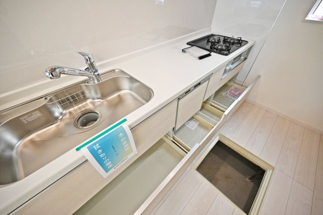 ブルーミングガーデン御願塚7目新築一戸建て|南向き3LDK+駐車1台可のキッチン|キッチン天板下いっぱいに収納庫を設けてあります。シンクした収納庫にはナイフホルダーも標準搭載。食器洗い乾燥機や浄水器一体型水栓も標準仕様のユニットが導入されています。