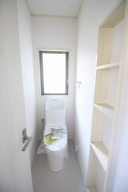 小山市中久喜1丁目のトイレ|1階トイレは新品に交換済み。明るい内装で清潔感があり、窓付きで換気もしやすい空間です。側面には収納棚もあり、トイレットペーパーや掃除用品の整理にも便利です。