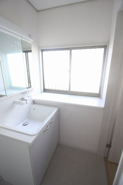 小山市中久喜1丁目の脱衣所|1階脱衣所。明るい内装にリフォームされ、清潔感のある仕上がりです。洗濯機置き場もしっかり確保されており、毎日の家事がしやすい快適なスペースです。