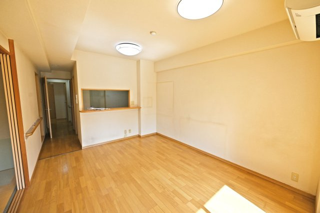 サンマンションアトレ吹田片山通りの居間・リビング|リビング側からダイニングとキッチンに向かって撮影した内観写真です。家具が配置しやすい形状の空間です。