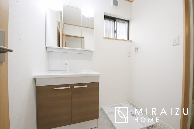 【洗面所】 | 洗濯機置き場と脱衣スペースもしっかりと確保されている洗面室、洗面コーナーは、窓から陽も差し明るく開放的な造りです。家事導線も良いので洗濯物やお湯はりもストレスフリーに毎日家事を楽しめそうです。
