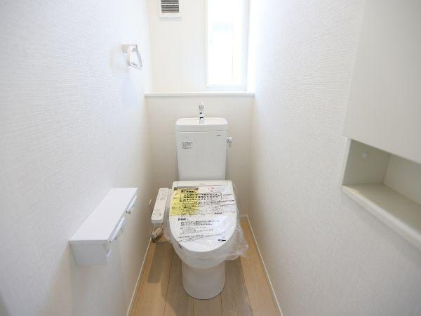 富士見が丘東第6-1号棟のトイレ|窓が設けられており換気しやすいトイレです。白を基調とした内装で明るい印象が感じられます。シンプルなデザインで清潔感があります。ペーパーホルダーや収納スペースも備わっています。