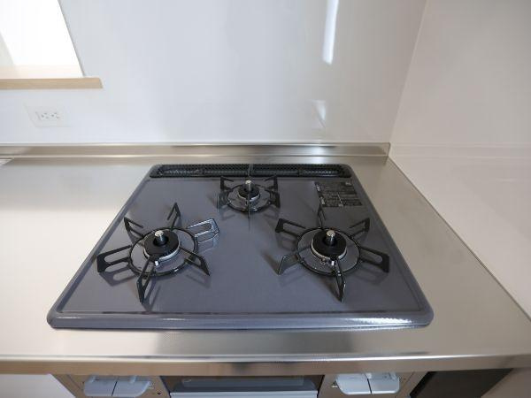 富士見が丘東第6-1号棟のキッチン|三口のコンロが備わったキッチンは調理の幅が広がります。すっきりとしたステンレスの天板はお手入れしやすい仕様です。窓が近くにあり換気もしやすいのが特徴です。使いやすさに配慮されたキッチンスペースです。